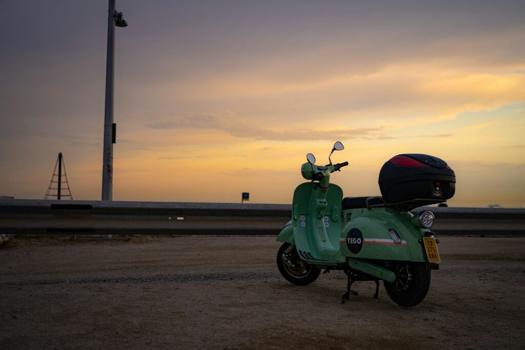 a green motorcycle parked on a beach